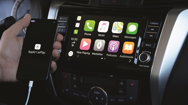 A man opening the Apple CarPlay app from his iPhone connected to the Renault Multimedia system